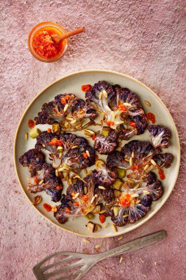 Coliflor morada al horno con puerros y pesto de tomates secos.